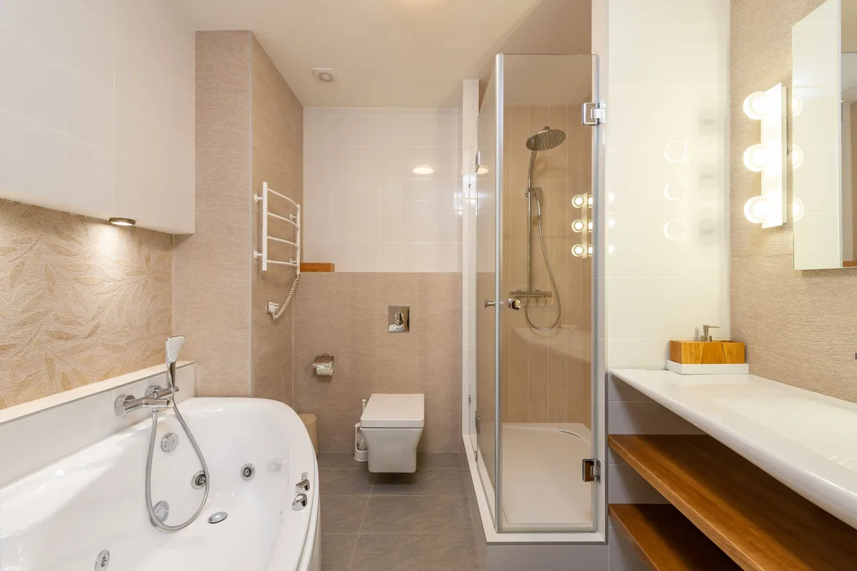 Bathroom with a corner tub next to a glass walk-in shower
