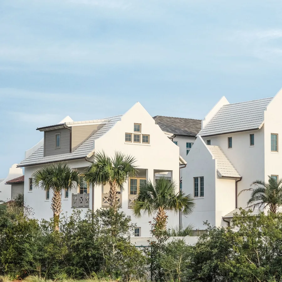 White coastal-style homes with tile roofs and palm trees in South Florida