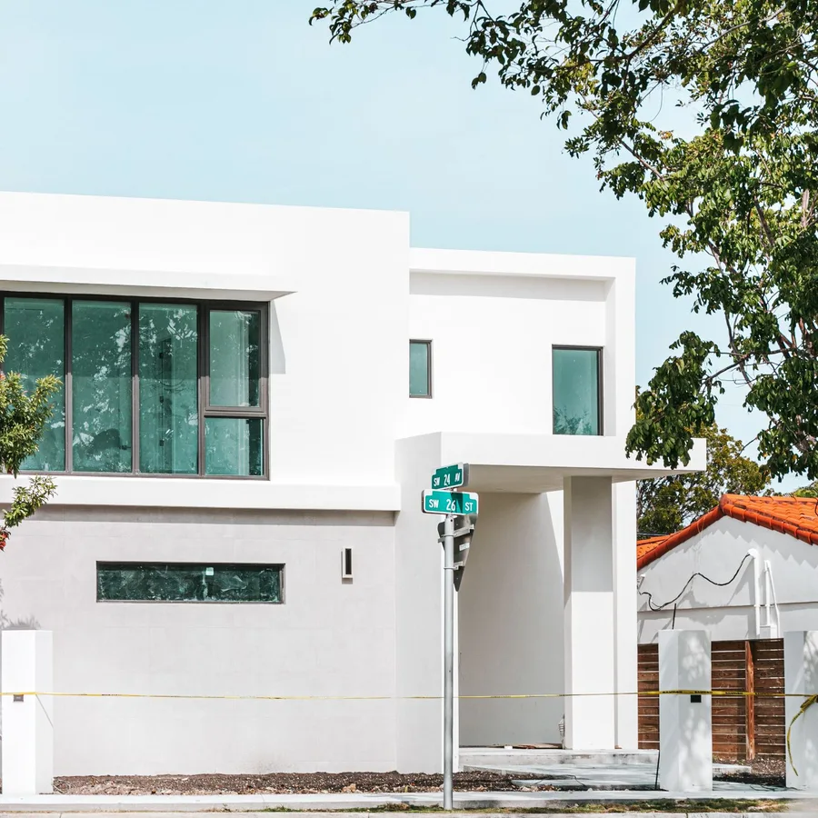 Modern white stucco home in South Florida with large black-framed windows