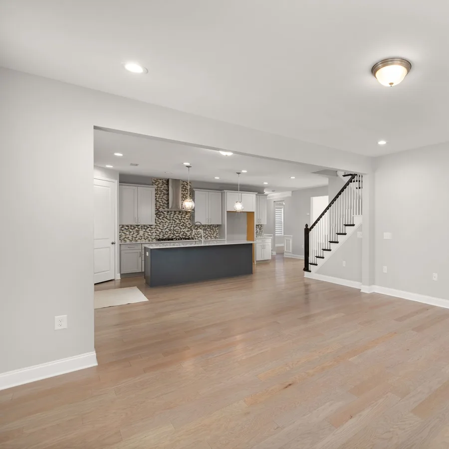 Open living area with new light wood-look flooring and freshly painted white walls