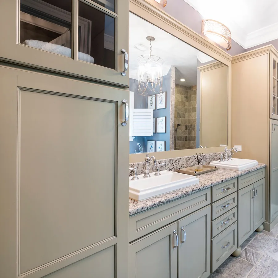 Bathroom with a sage green vanity, granite counter and a stone-tile walk-in shower